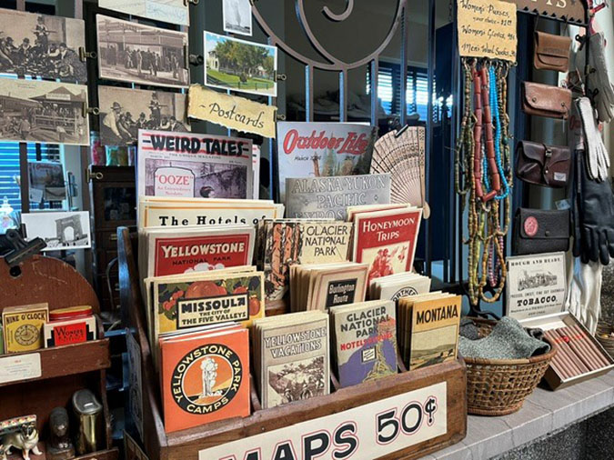 Antique props, including old national park maps, are placed along the old ticket booths inside the train depot in Butte during filming Antique props, including old national park maps, are placed along the old ticket booths inside the train depot in Butte during filming