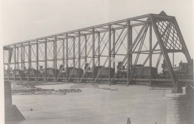 A string of steam locomotives crosses the bridge in the late 1800s. A string of steam locomotives crosses the bridge in the late 1800s.