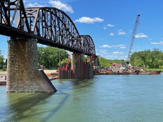 Evidence of work on the new bridge starts to emerge from the water next to the existing bridge. Evidence of work on the new bridge starts to emerge from the water next to the existing bridge.