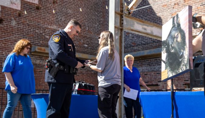 K-9 Faust is honored at the We Ride to Provide (WRTP) K-9 Memorial. His handler, BNSF Senior Special Agent Bryan Schaffer, accepts the award. K-9 Faust is honored at the We Ride to Provide (WRTP) K-9 Memorial. His handler, BNSF Senior Special Agent Bryan Schaffer, accepts the award.