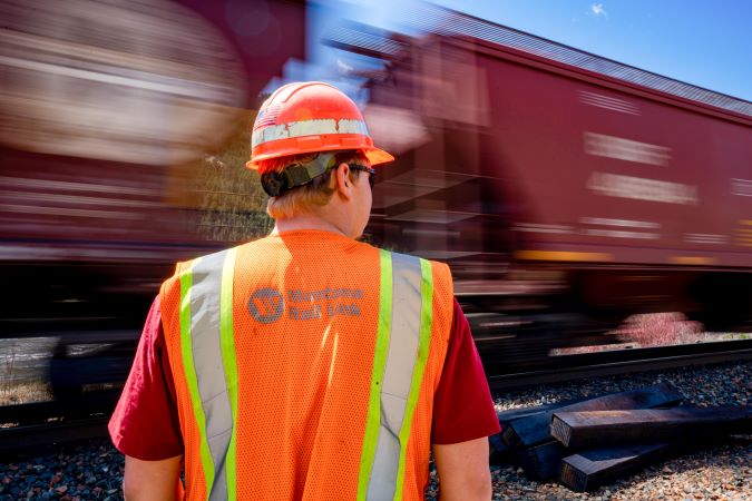 A BNSF grain train passes by an MRL employee A BNSF grain train passes by an MRL employee